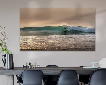 Surfer op een kleinere golf op het strand van de Atlantische Oceaan van Jonas Weinitschke