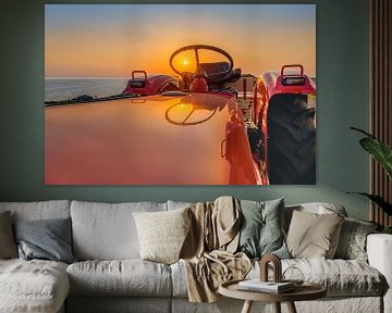 Sunset through the wheel of a tractor by Harrie Muis