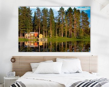 naaldbos en houten recreatiewoning reflecteren in Zweeds meer van Jan Fritz