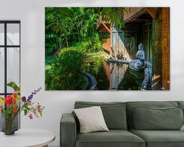 Buddha statue in a pond in front of a house by Rene Siebring