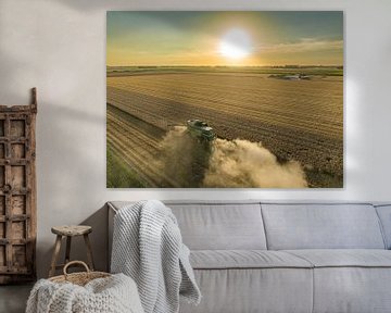 Combine oogst tarwe tijdens zomerse zonsondergang van Sjoerd van der Wal