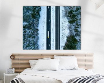 Highway through a snowy forest landscape seen from above