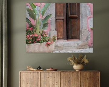 Openslaande deur tussen roze stenen en bloemen op Gran Canaria van Judith van Wijk