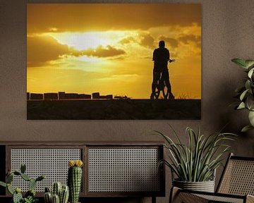 Silhouet van eenzame fietser die geniet van zonsondergang boven de Westerschelde. van Gert van Santen