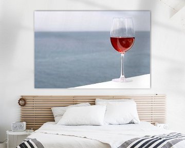 Glass with pink wine, sea in background