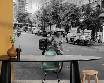 Vrouw met fiets loopt over straat in HCMC van Bart van Lier