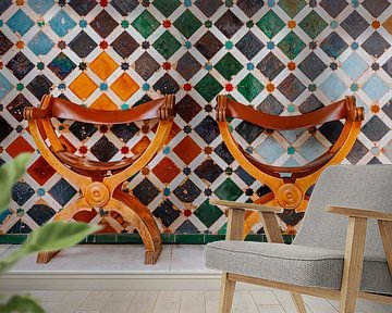 Zwei authentische Stühle vor einer Mosaikwand von Ben De Kock