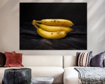 Een tros van drie bananen op een mooi belichte donkere ondergrond. van René Ouderling