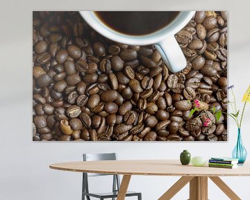 Geroosterde koffiebonen en een kopje koffie op een tafel van Heiko Kueverling