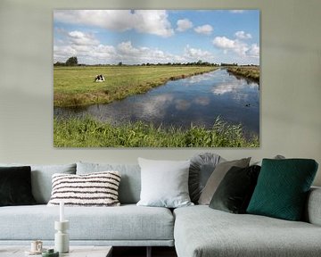 polder landschap met een rustende koe en stapelwolken van W J Kok