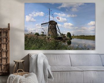 Traditionele molens op de kinderdijk op een mooie zomerse dag versierd met Nederlandse vlaggen van W J Kok