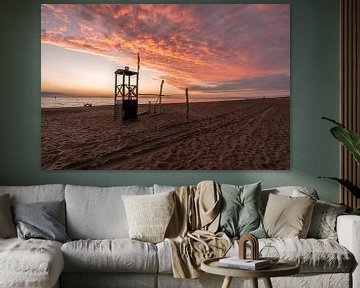 Kleurrijke zonsondergang met houten strandhuis van Dafne Vos
