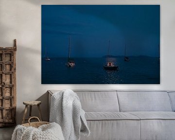 Sailboats at anchor on the beach by moonlight