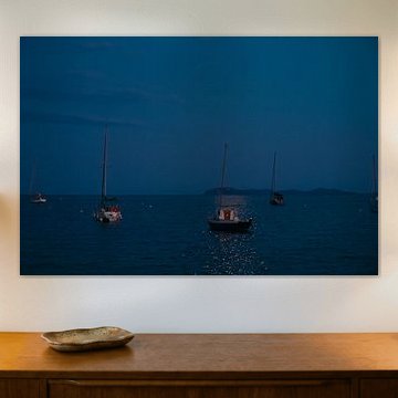Sailboats at anchor on the beach by moonlight