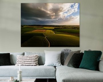 Nuages d'orage sur des champs verts sur Luc van der Krabben