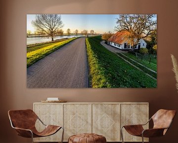 Boerderij langs de Maas in de late avondzon. van John Duurkoop