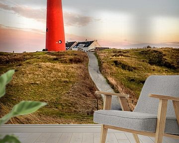 Path leading to a red lighthouse in the dunes 