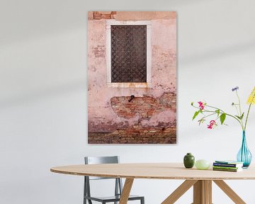Roze vergane muur met een rechthoekig raam en gietijzerwerk in Venetië