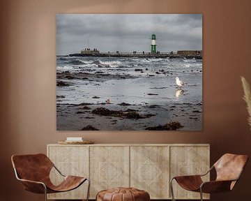 Vuurtoren van Warnemünde met meeuw op het strand van Bild.Konserve