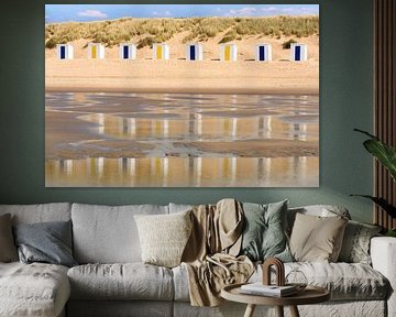 Strandhuisjes weerspiegeld in het water van de zee van Lisette Rijkers