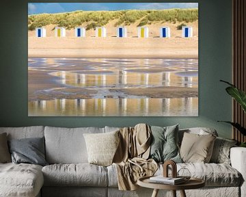 Strandhuisjes weerspiegeld in het water van de zee van Lisette Rijkers