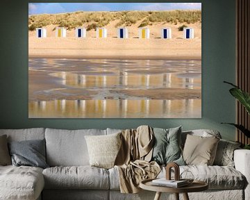 Strandhuisjes weerspiegeld in het water van de zee van Lisette Rijkers