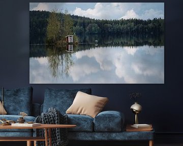 Reflexion eines schwedischen kleinen Gebäudes auf einem spiegelglatten See von Bart cocquart