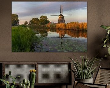 Molen tijdens zonsondergang, met reflectie in het water van Bram Lubbers