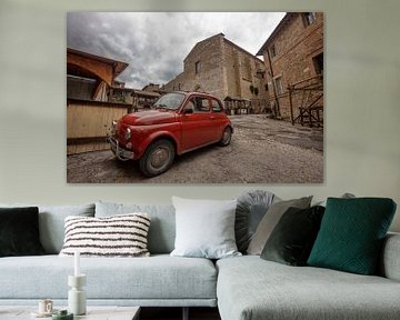 Rotes Auto (Fiat 500) auf einem Platz in Bevagna, Italien von Joost Adriaanse