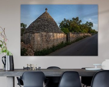 Trullo (maison en pierre) le long d'une route dans la lumière du soir, sud de l'Italie sur Joost Adriaanse