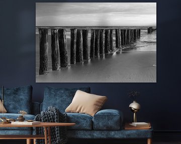 Rangée de poteaux sur la côte de la mer du Nord près de Schoorl, noir et blanc sur Bram Lubbers