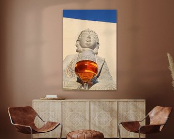 Buddha with a wine glass against wall and bright blue sky by Studio LE-gals