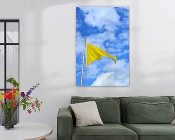 Gele wapperende vlag voor een blauwe lucht met wolken van Lilly Wonderz