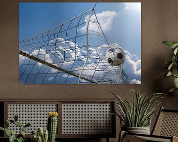 Symbolisch voetbaldoelpunt: bal landt hoog in het net van een voetbal van Udo Herrmann