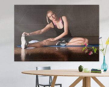 Blondine rekt zich uit in een sportschool van Tilo Grellmann