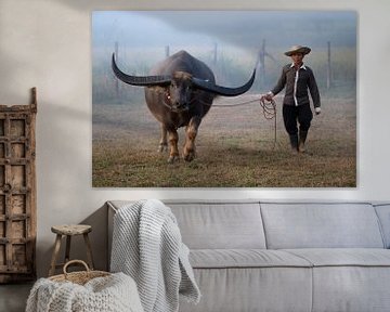 Farmer with his water buffalo in the field by Anges van der Logt