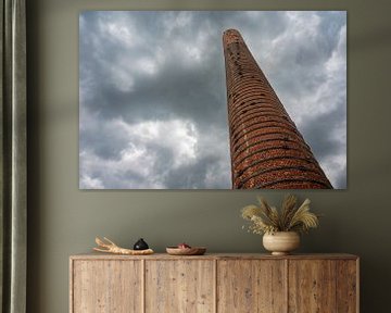 Low angle view over a high brick stone chimney van Werner Lerooy