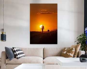 Man with dog in sunset by J. Einmahl