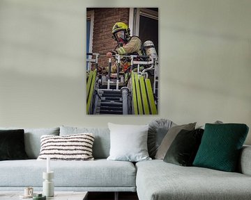 Brandweerman tijdens een inzet met de ladderwagen. van Meterfotografie