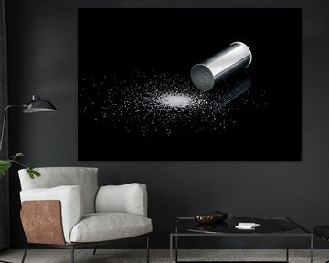 Salt shaker on a black background with grains of salt. by Nelemonsi Photo Art