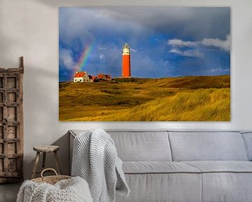 Texelse vuurtoren in de duinen met een regenboog tijdens een stormachtige aut