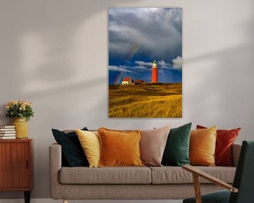 Texel lighthouse in the dunes with a rainbow during a stormy aut