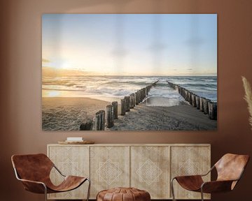 Wellenbrecher am Strand während eines stimmungsvollen Sonnenuntergangs von John van de Gazelle