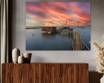 Sonnenuntergang am Pier in der Fischerhütte mit Fischernetz in der Lagune von Comacchio in Italien von Animaflora PicsStock