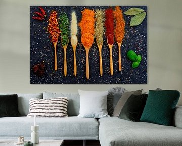 Bright spices and herbs on wooden spoons by Francis Dost