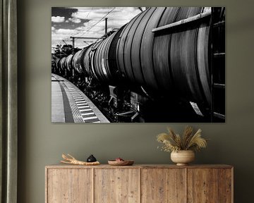 Zwart-wit foto van een goederentrein bij een perron van Wim Stolwerk