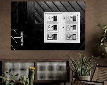 Black-and-white photograph of a door with door handle and lockers. by Wim Stolwerk