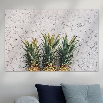 Three pineapples on white marble