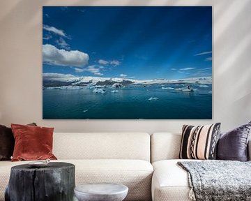 Iceland - White snow on glacier behind glowing icebergs and tourist boat far away by adventure-photos