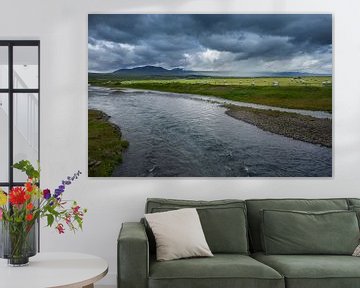 Islande - Des centaines de bottes de foin derrière la rivière dans une prairie verdoyante sur adventure-photos